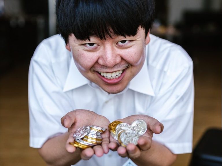 Man in White Button Up Shirt Holding Gold and Silver Coins