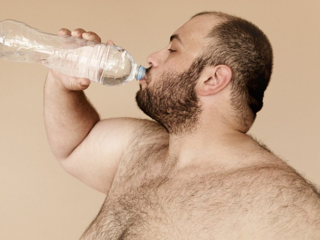 Man Drinking from Clear Plastic Bottle