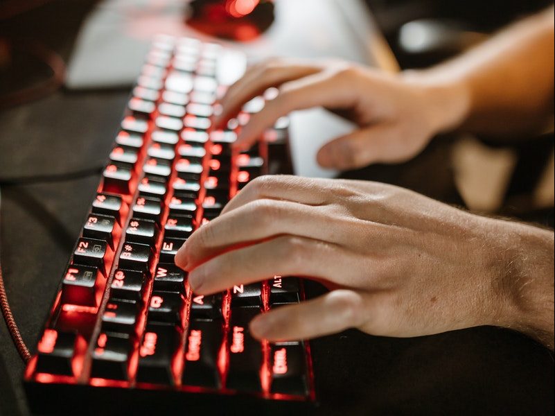 Close-Up Photo of Person's Hands on Mechanical Keyboard
