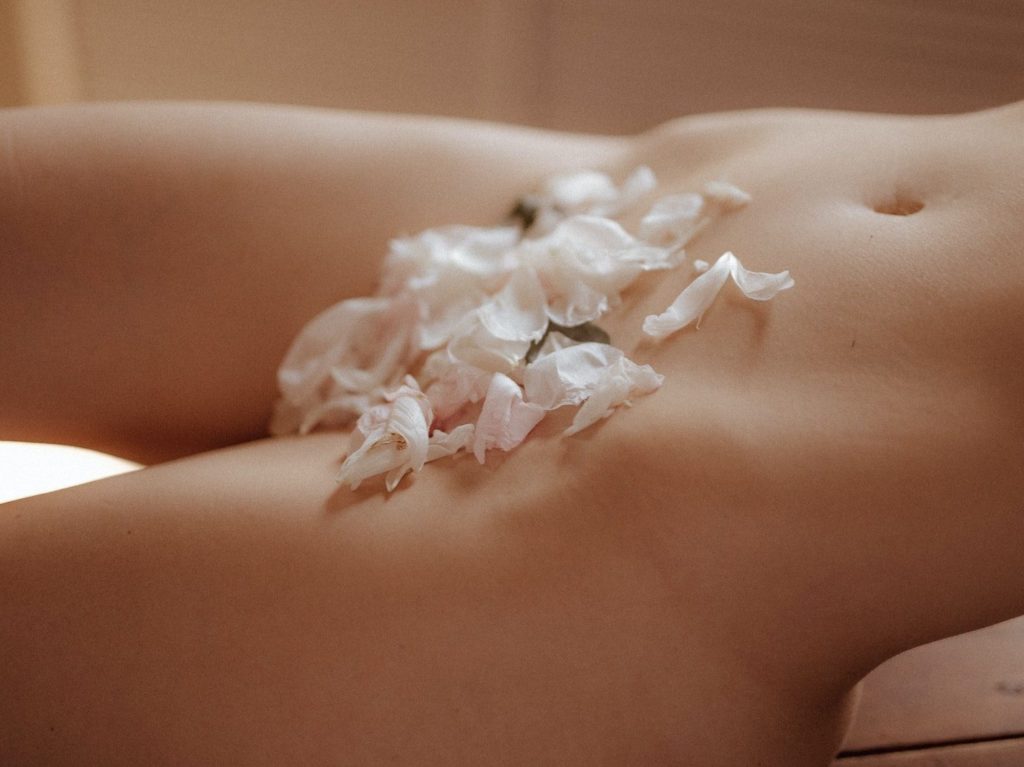 Naked Woman with Flower Petals Covering Parts of Her Body