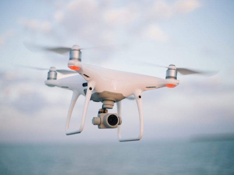 close up photography of drone flying over body of water at daytime