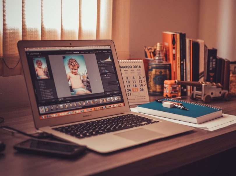 Turned on Screen Silver Macbook Air on Wooden Desk