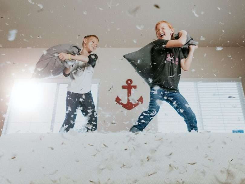 two toddler pillow fighting