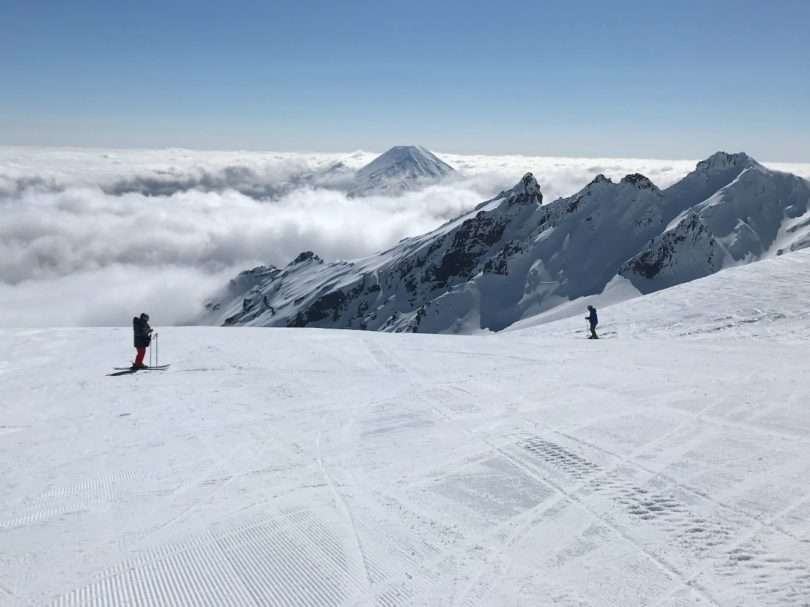 person in black jacket standing on snow covered mountain during daytime