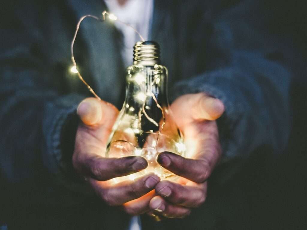 man holding incandescent bulb