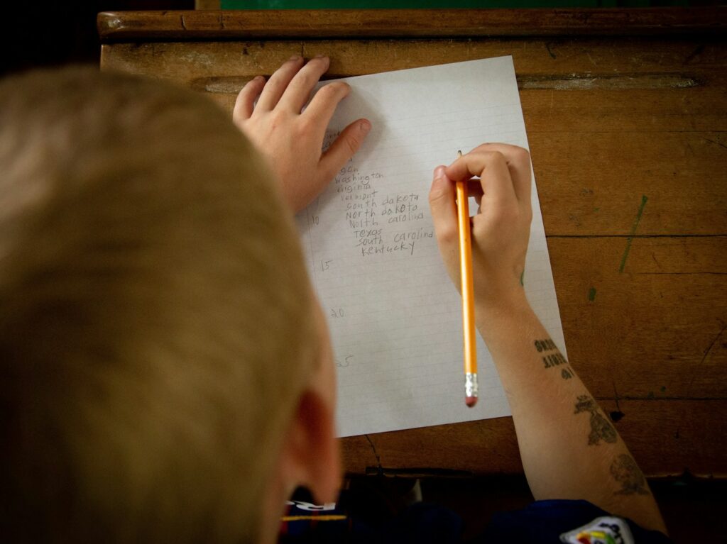 person writing on white paper